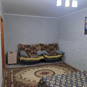 a room with a couch and a bed and a rug at 1 комн квартира рн Сазда БЦ МИР в Центре in Aktobe