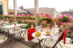 2 Tische und Stühle auf einem Balkon mit Blumen in der Unterkunft Mikon Eastgate Hotel - City Centre in Berlin