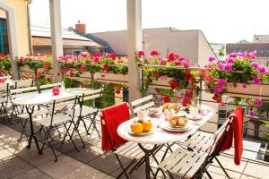 two tables and chairs on a balcony with flowers at Mikon Eastgate Hotel - City Centre in Berlin