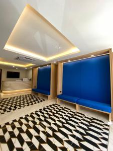 Cette chambre est dotée de murs bleus et d'un sol en damier. dans l'établissement Armoni Patong Beach Hotel, à Patong Beach 148 autres photos