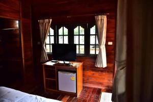 een slaapkamer met een bed en een tv op een tafel bij Little Home Beach in Ban Khok Rak