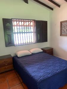 une chambre avec un lit bleu et une fenêtre dans l'établissement Finca Hotel El Juncal, à Venecia