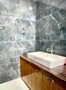 a bathroom with a white sink on a counter at Owls Oasis Kaziranga in Kāziranga