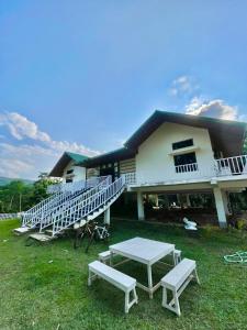 a building with a table and benches in front of it at Owls Oasis Kaziranga in Kāziranga