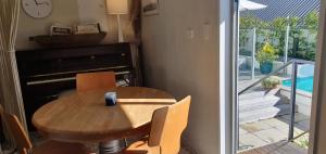 a table and chairs and a piano in a room at Stillpoint Retreat in Motungarara