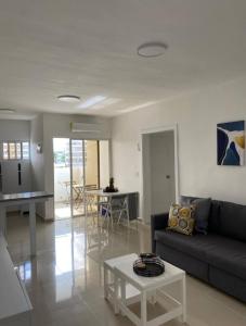 un soggiorno con un divano e un tavolo di Fully furnished 2 bedroom appart a Bayahibe