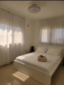 una camera da letto con un letto bianco con un asciugamano sopra di Fully furnished 2 bedroom appart a Bayahibe