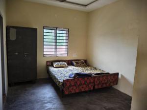 een slaapkamer met een bed in een kamer met een raam bij mithra house in Khammam