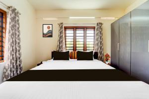 a bedroom with a large bed and a window at Townhouse Kalady Near Airport in Cochin