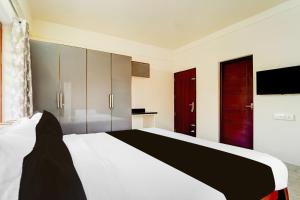 a bedroom with a large white bed and a tv at Townhouse Kalady Near Airport in Cochin