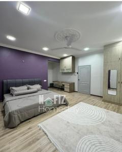 a bedroom with a bed and a purple wall at NAFIZ Pool Homestay Melaka - Fully AC 4 Rooms with 3 Toilets, PS4 in Kampong Alor