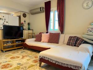 a living room with a couch and a flat screen tv at Villa with private pool in Alaçatı in Ilıca