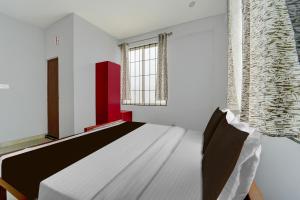 een slaapkamer met een bed en een raam bij Super Hotel O Pukkattupady Aluva East in Cochin