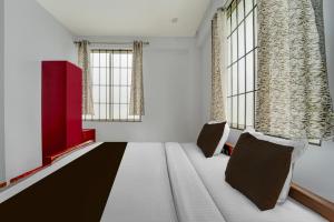 een kamer met een bank en 2 ramen bij Super Hotel O Pukkattupady Aluva East in Cochin