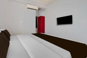 een slaapkamer met een bed en een televisie aan de muur bij Super Hotel O Pukkattupady Aluva East in Cochin +22 foto's