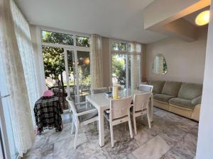 a dining room with a table and chairs and a couch at Villa with private pool in Alaçatı in Ilıca