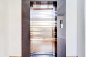 a elevator with a metal door in a building at Super Hotel O North Kalamassery in Cochin