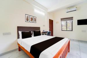 Giường trong phòng chung tại Hotel O HMT Colony Kochi Formerly Pullans Arcade