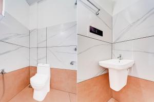 a white bathroom with a toilet and a sink at Super Hotel O North Kalamassery in Cochin +21 photos