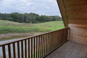 a balcony of a cabin with a view of a field at Pirts Rudzupuķes in Svente