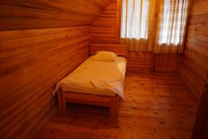 a small room with a bed in a cabin at Pirts Rudzupuķes in Svente +5 photos
