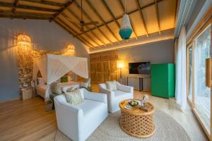 ein Wohnzimmer mit zwei weißen Stühlen und einem Bett in der Unterkunft Bawe Island Zanzibar in Zanzibar City