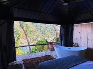 een slaapkamer met een bad en uitzicht op een berg bij Kainga in Puerto Vallarta