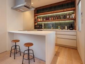 a kitchen with a bar with two stools at -new-SHELL THE THIRD in Kamakura