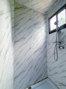 a shower in a bathroom with white marble walls at Nawesa Resort in Eton +88 photos