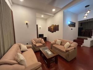 un salon avec des canapés, des chaises et une table dans l'établissement Punida villa, à Mirissa