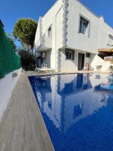 a villa with a swimming pool in front of a house at Villa with private pool in Alaçatı in Ilıca