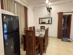 une salle à manger avec une table et un réfrigérateur noir dans l'établissement Punida villa, à Mirissa 11 autres photos