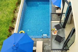 an overhead view of a swimming pool with blue umbrellas at SEAESTA An Bang in An Bàn (2)