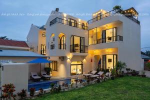 a large white house with a swimming pool in front of it at SEAESTA An Bang in An Bàn (2)