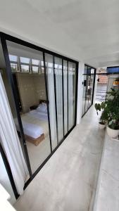 a bedroom with glass walls and a bed on a balcony at Kalih Rooms in Ubud