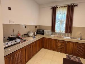 une cuisine avec des armoires en bois et un comptoir dans l'établissement Punida villa, à Mirissa