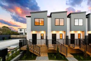 ein Haus mit Sonnenuntergang im Hintergrund in der Unterkunft Glen Eden Haven in Auckland