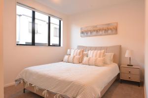 ein Schlafzimmer mit einem Bett mit zwei Kissen und einem Fenster in der Unterkunft Glen Eden Haven in Auckland + 8 Fotos