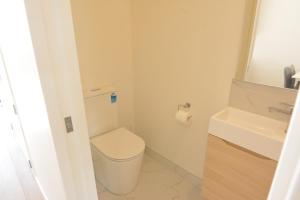 a small bathroom with a toilet and a sink at Modern 3BR Family Townhouse & Walk to Train & Free Parking & Gated Community in Auckland +26 photos
