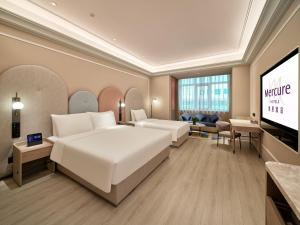 a hotel room with a bed and a flat screen tv at Mercure Beijing Universal Resort in Beijing +126 photos