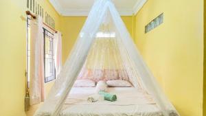 a child laying on a bed in a room at Sumatra Cheeky Monkeys in Bukit Lawang