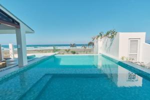een zwembad met strand op de achtergrond bij Alesea Baroro, La Union, Private Modern Villa with Pool, Jacuzzi, Beachfront View in Balio