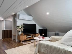 a living room with a flat screen tv at Brigidas Guest House in Bairnsdale