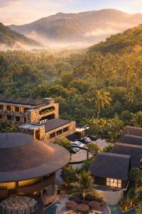 a view of a resort with mountains in the background at Quenzo Beach Resort in Padangbai