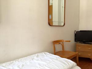 a bedroom with a bed and a chair and a mirror at Linné Hostel in Gothenburg