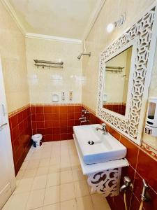 une salle de bains avec un lavabo blanc et un miroir dans l'établissement Candolim beach apartment goa, à Candolim