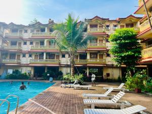 un hôtel avec une piscine devant un bâtiment dans l'établissement Candolim beach apartment goa, à Candolim