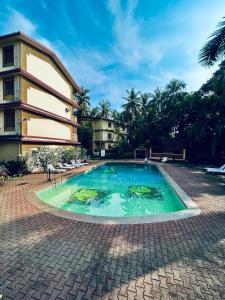 une piscine devant un bâtiment dans l'établissement Candolim beach apartment goa, à Candolim