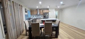 a kitchen and dining room with a table and chairs at HolidaysHouse Close to Melbourne in Truganina +9 photos