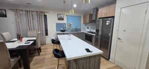 a kitchen with a white counter top and a refrigerator at HolidaysHouse Close to Melbourne in Truganina